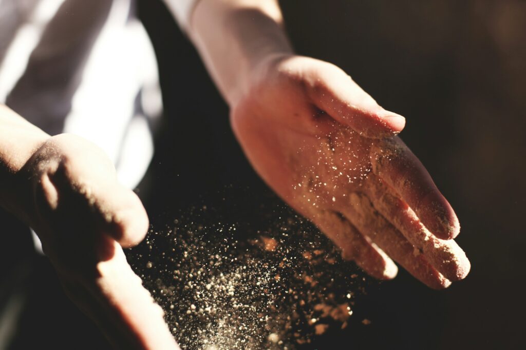 Hands that are clapping, with sand in them