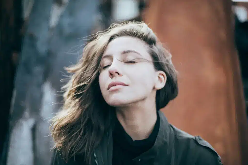 Woman enjoying the wind outside with her eyes closed