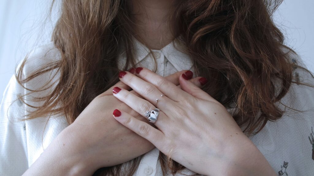 Woman holding her hands over her heart