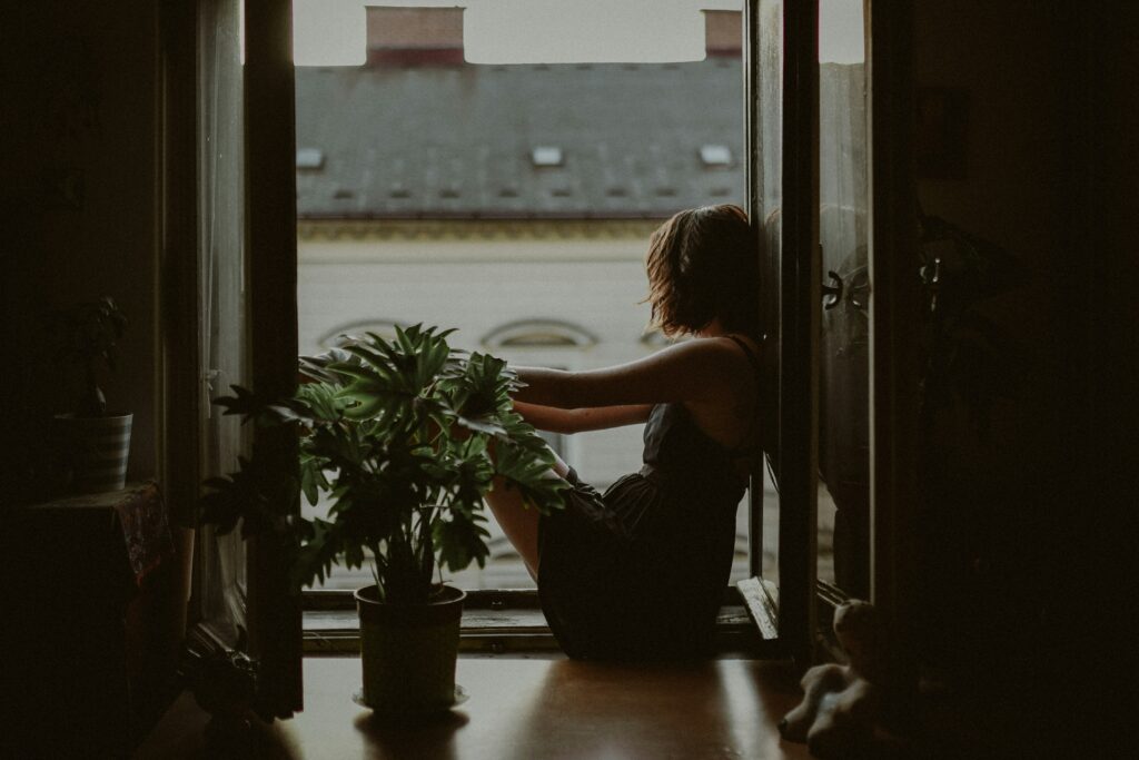 Woman sitting in the window looking outside