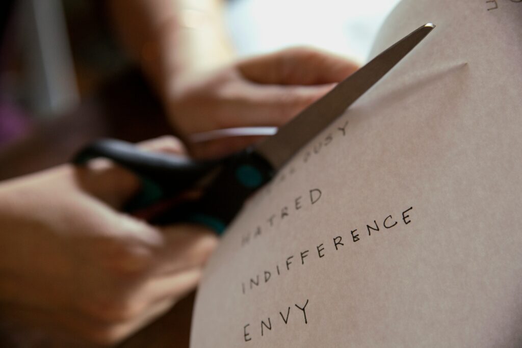 Woman cutting in a piece of paper with words on it